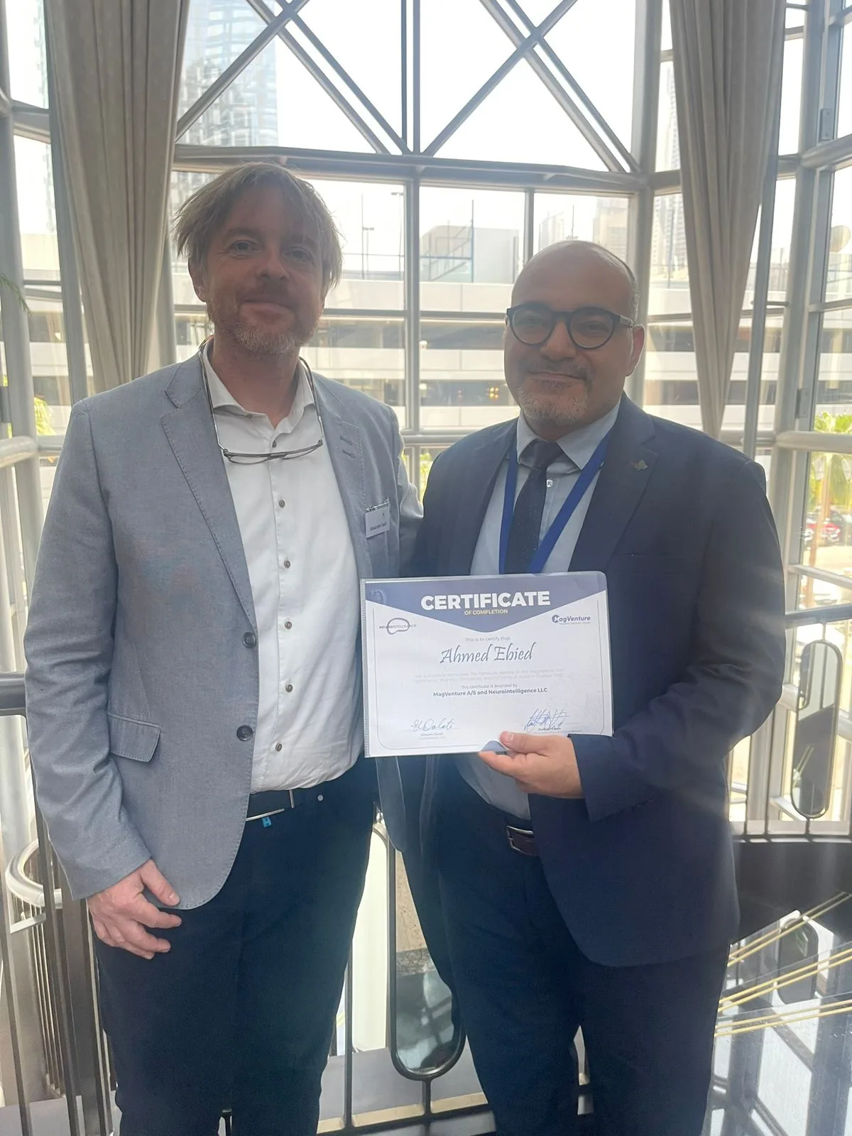 Dr. Ahmed Ebied receiving a certificate of completion for specialized neurological training.