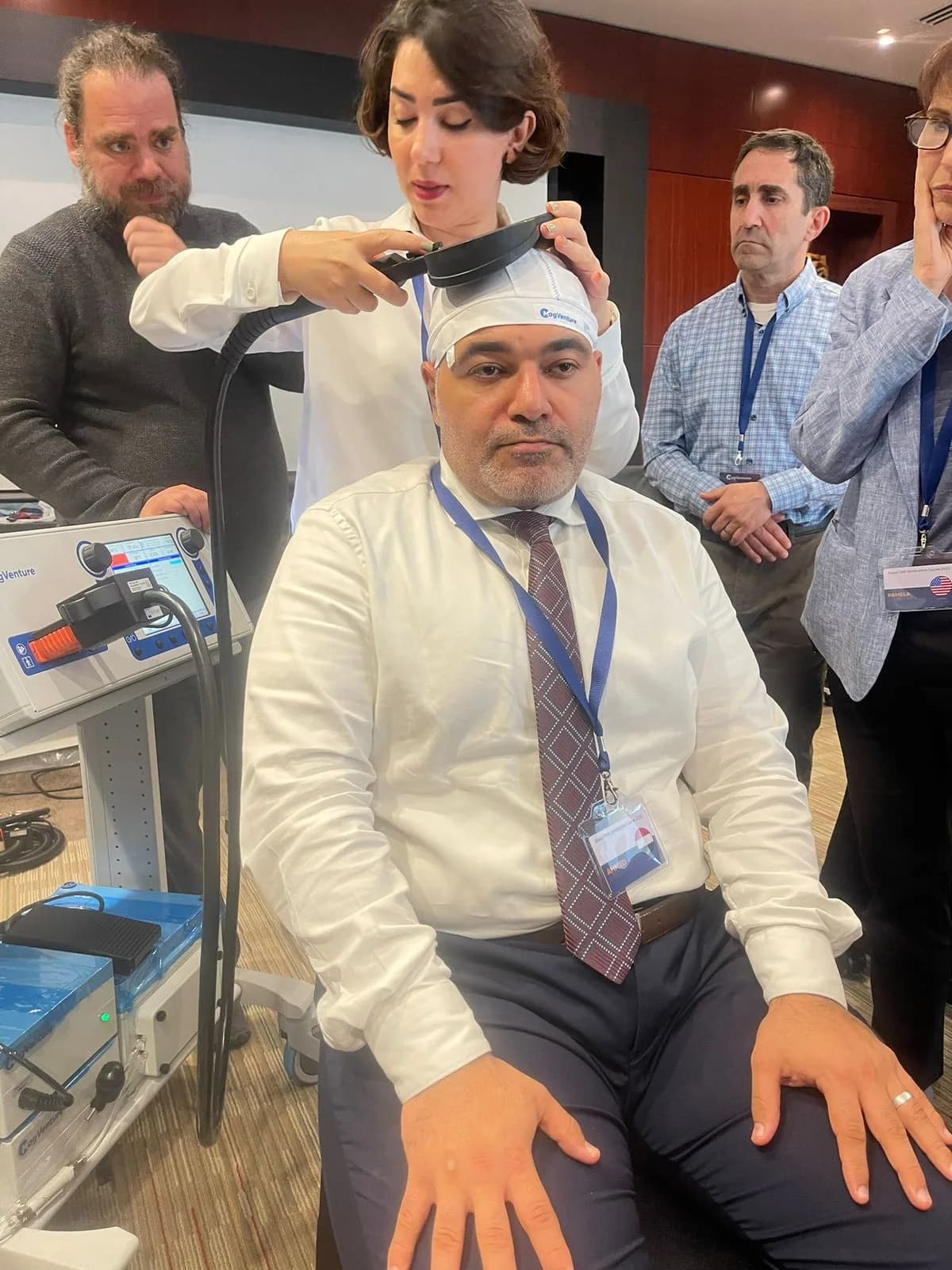 Dr. Ahmed Ebied during a practical demonstration of Transcranial Magnetic Stimulation (TMS) therapy.